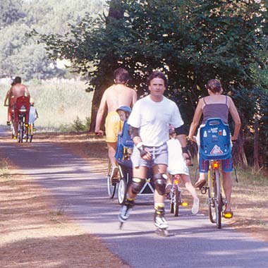 Campeurs à vélo et en rollers sur une allée du camping Moussaillon à Messanges