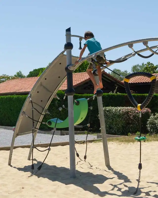 Enfant jouant sur le toboggan l'aire de jeu du camping à Messanges