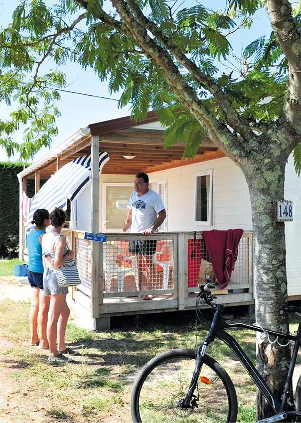 Famille sur la terrasse d'une location de mobil-home dans les Landes