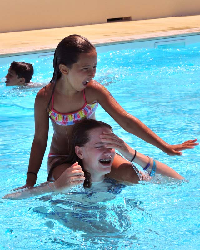 Jeunes filles jouant dans la piscine du camping dans les Landes