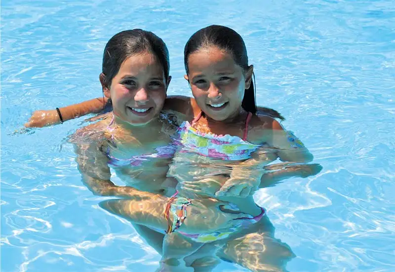 Fillettes se baignant dans la piscine du camping dans les Landes
