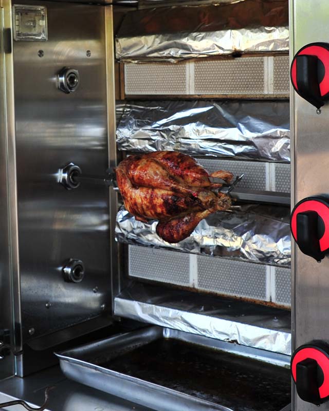 Poulet en train de rôtir sur une broche au camping dans les Landes