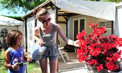 Fleurs et famille devant un mobil-home à louer dans les Landes