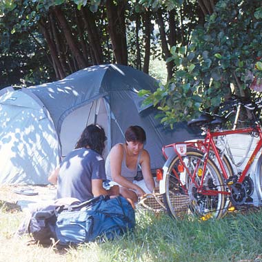 Pareja de campistas con carpa y bicicletas en el camping de Messanges en los años 90