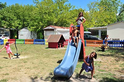 Niños jugando en un tobogán en el patio de recreo del camping en Messanges cerca de Vieux-Boucau