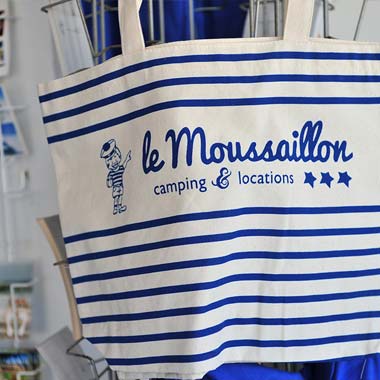 Bolsa de tela blanca y azul con el logo del camping Le Moussaillon en Messanges
