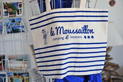 Bolsa de tela blanca y azul con el logo del camping Le Moussaillon en Messanges