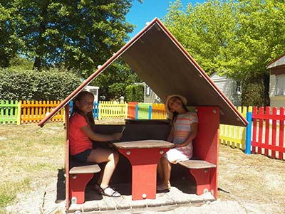 Cabaña lúdica con dos niñas en el patio de recreo del camping en las Landas cerca de e Vieux-Boucau