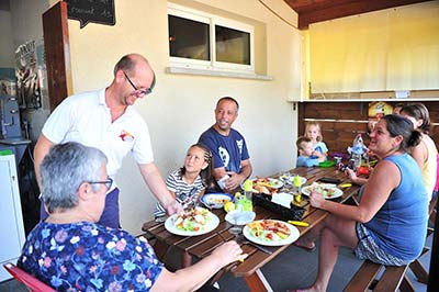 Campistas sentados para almorzar en el camping Moussaillon de Messanges