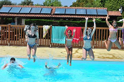 Young girls jumping into the pool at the campsite near Capbreton in Messanges