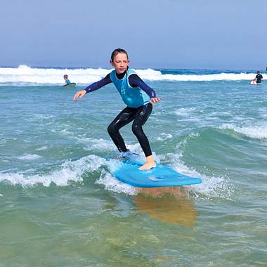 Niño aprendiendo a surfear durante un curso de surf cerca de Messanges en las Landas
