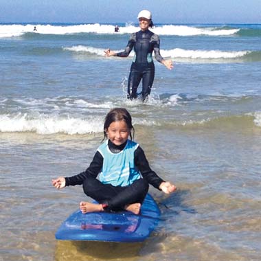 Child by the sea on a surfboard near Hossegor